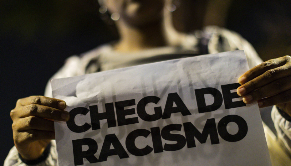 Mulher segura cartaz contra o racismo. Fonte: CSP-Conlutas